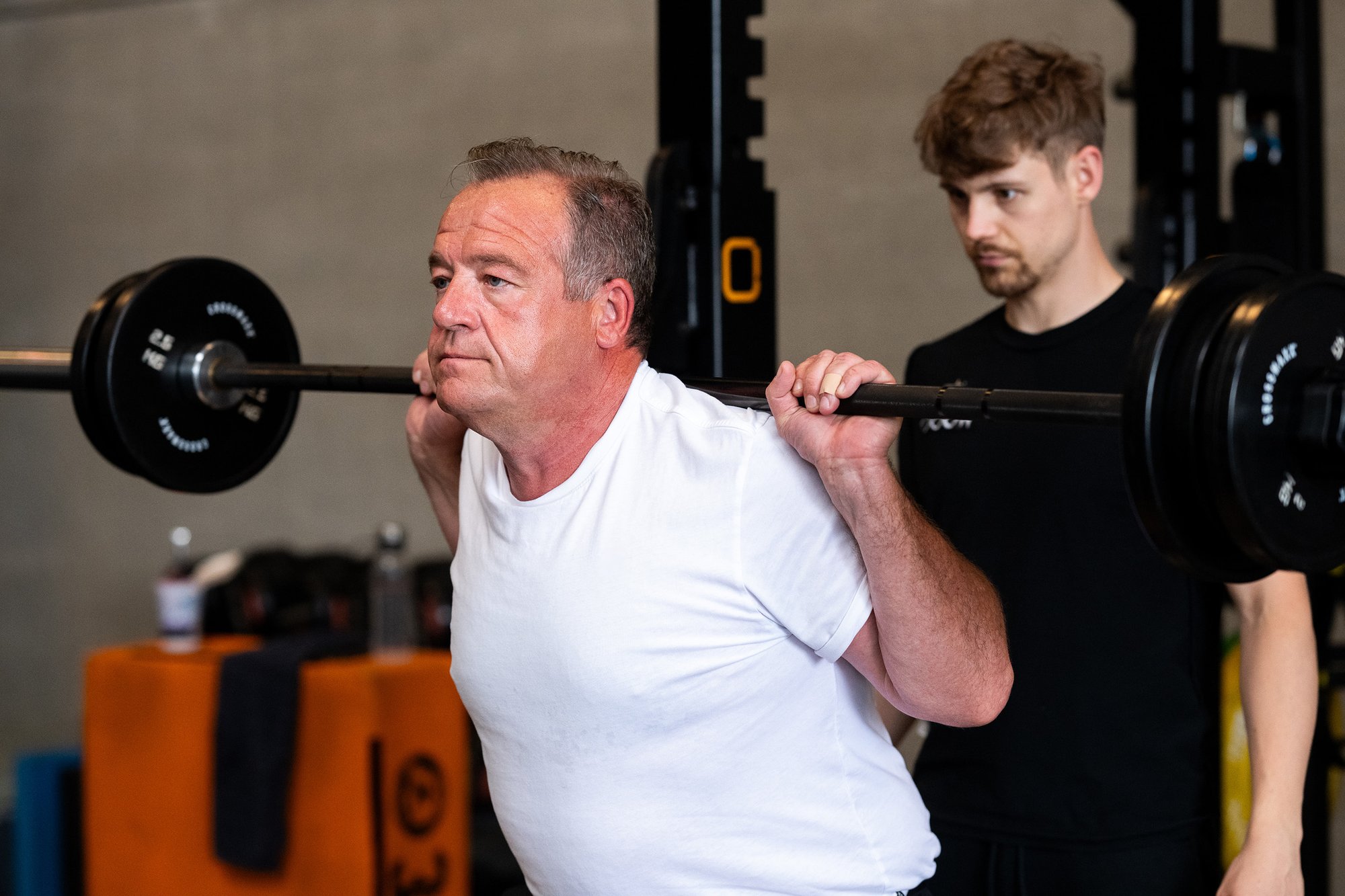 Personal coach begeleidt ondernemer tijdens een squat bij WOOO Personal Coaching.