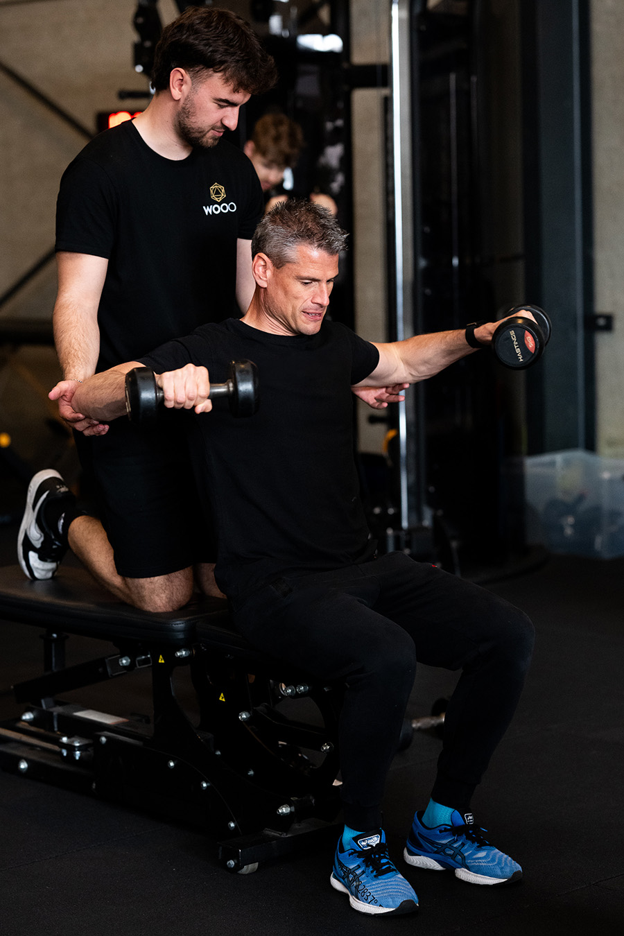 Ondernemer doet aan krachttraining met gewicht uit onder begeleiding van zijn personal coach tijdens personal training bij WOOO in Brecht. Ondernemer doet aan krachttraining met gewicht uit onder begeleiding van zijn personal coach tijdens personal training bij WOOO in Brecht.